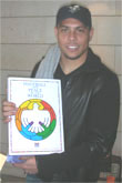 Ronaldo, la estrella brasilera del futbol mundial, posa con el libro Fútbol y Paz en el Mundo